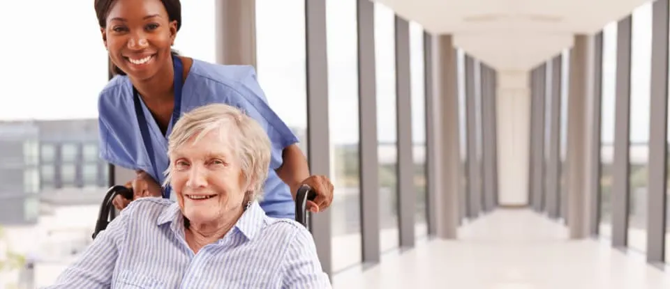 Old woman in a wheelchair with her caregiver