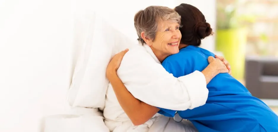 Caregiver is hugging the old lady